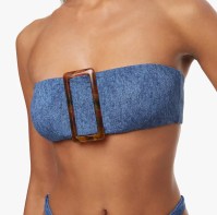 a decorative brown plastic buckle on a blue denim bandeau top intended for street wear
